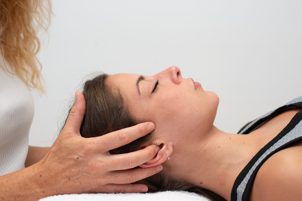 Terapeuta realizando masaje creaneosacral a paciente