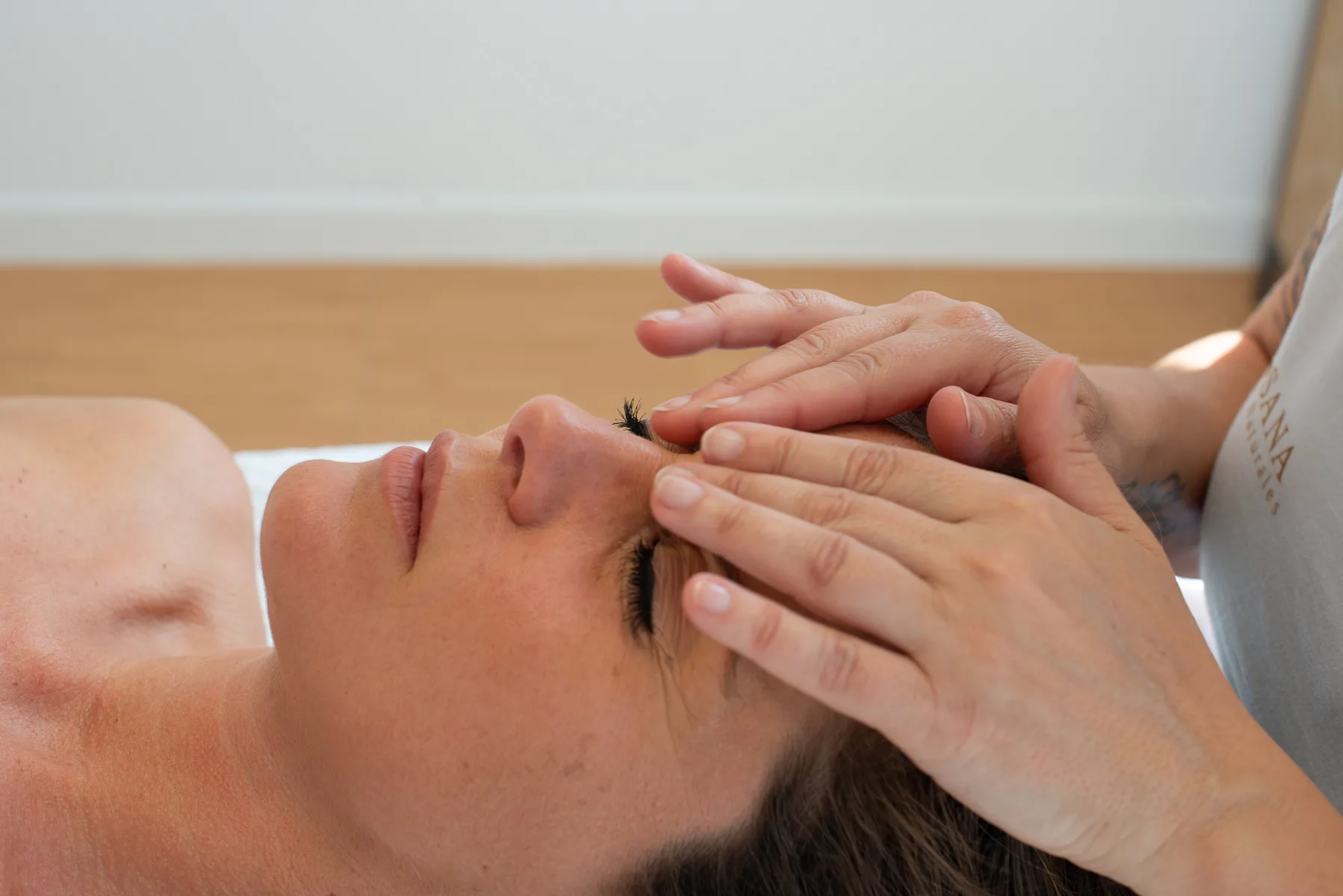 Chiropractor performing facial massage for client