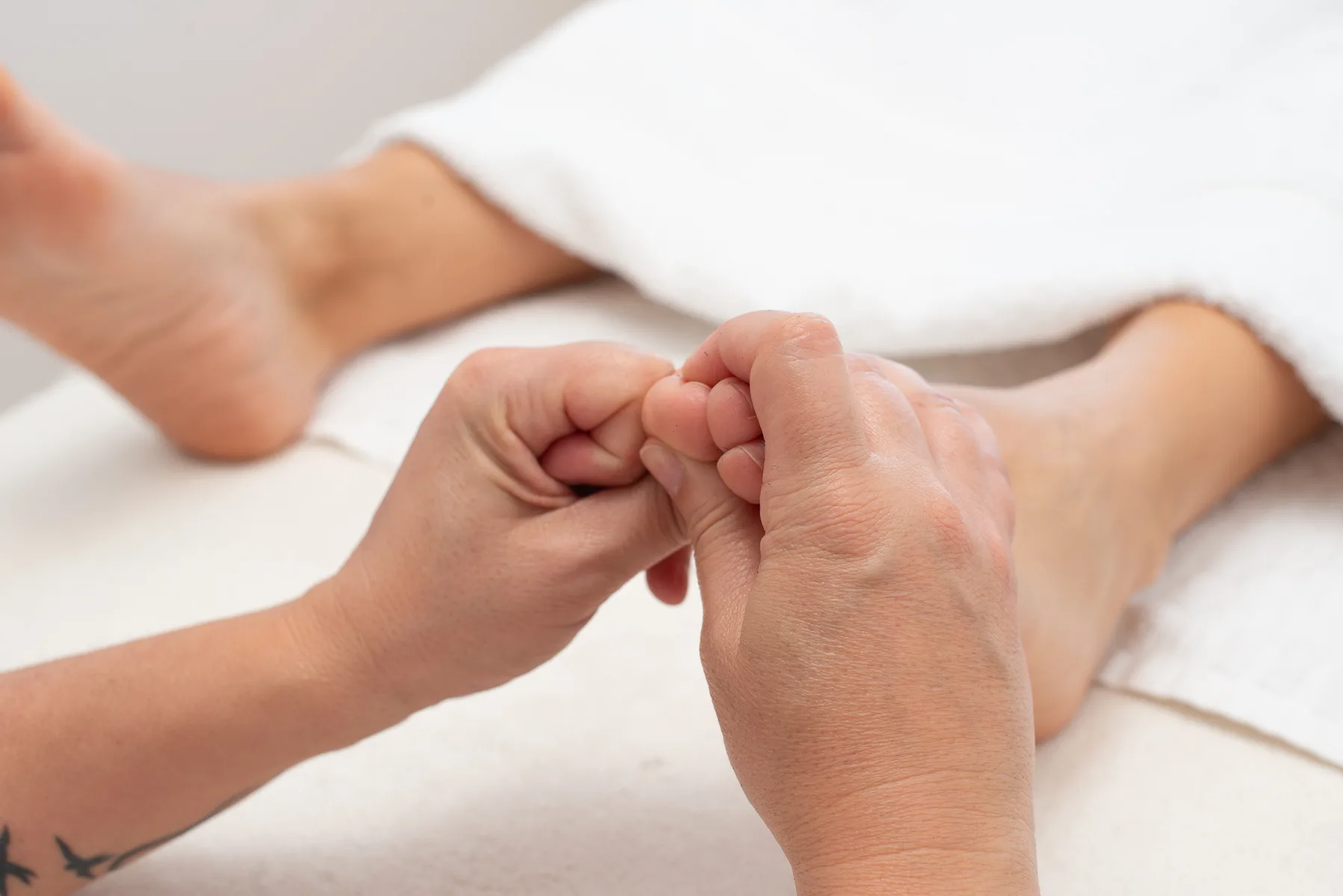 chiropractor performing foot massage on patient
